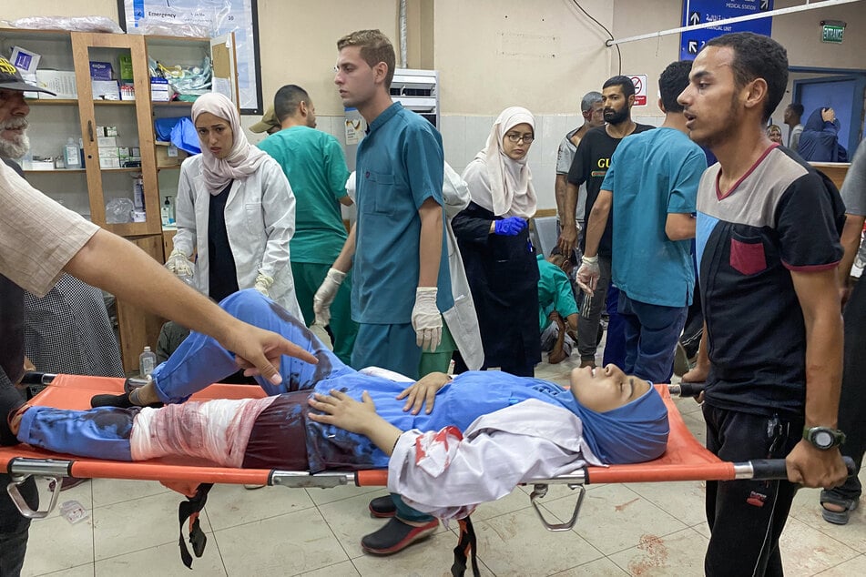 Palestinians transport a medic injured in Israeli strikes on Nasser hospital in Khan Younis in the southern Gaza Strip on August 25, 2025.