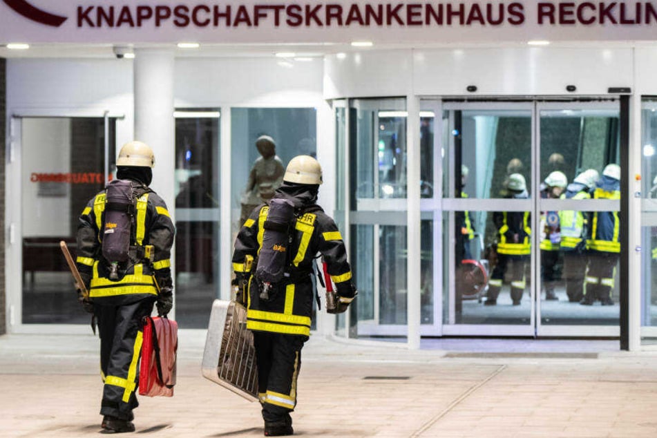 Einsatzkräfte der Feuerwehr gehen mit ihrer Ausrüstung zum Haupteingang des Knappschaftskrankenhauses.