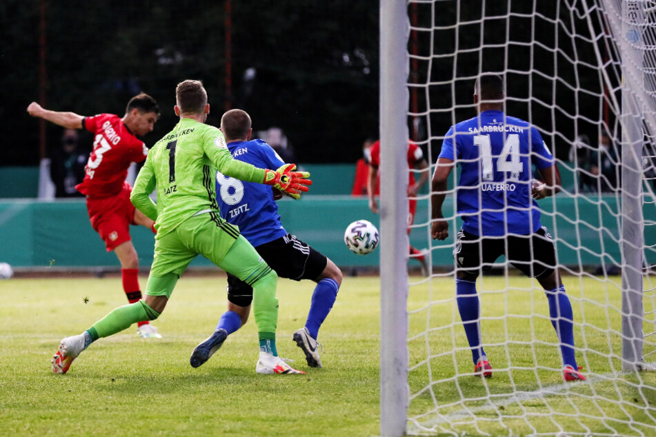 Leverkusens Stürmer Lucas Alario (rotes Trikot) trifft an allen Saarbrücker Abwehrspielern vorbei zum 2:0 für Bayer.
