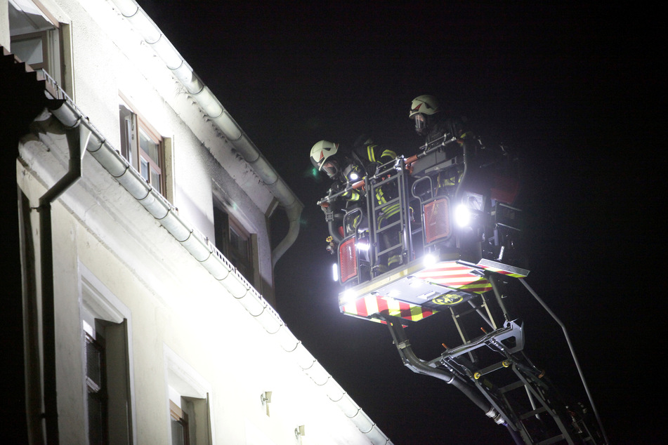 Mithilfe einer Drehleiter leuchteten Feuerwehrleute in die brennende Küche, um dort zu löschen. Den Strom in der Brandwohnung hatten die Kameraden vor Beginn der Löscharbeiten aus Sicherheitsgründen abgeschalten.