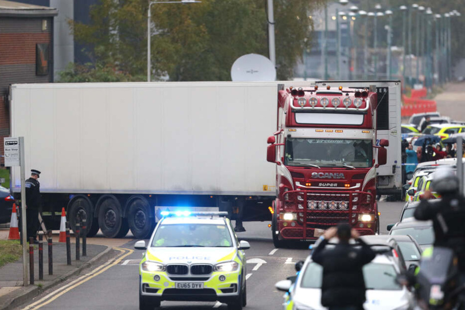 Ein Polizeiauto eskortiert den LKW, in dem 39 Leichen gefunden worden waren, beim Verlassen des Waterglade Industrieparks.