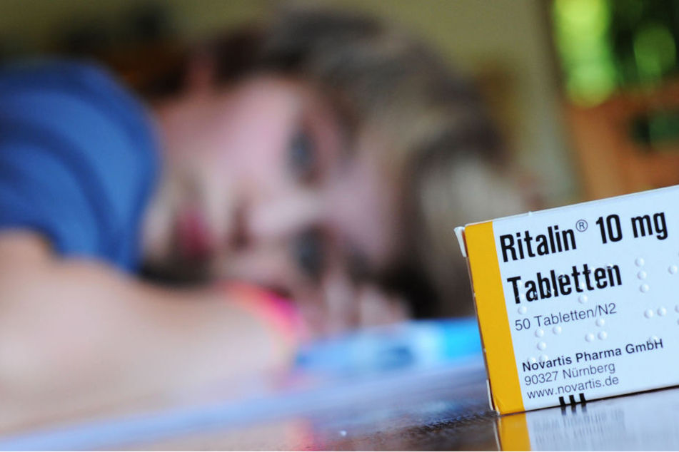 ine Packung des Medikaments Ritalin des Herstellers Novartis steht auf einem Tisch, an dem ein zehnjähriger Junge seine Hausaufgaben erledigt.