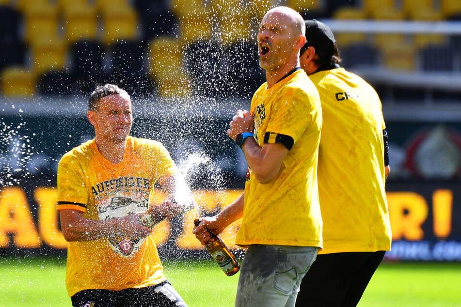 Ausgelassener Jubel: Nach dem geschafften Aufstieg gab es von Chris Löwe (32, l.) die Bierdusche für Coach Alexander Schmidt (52, M.).