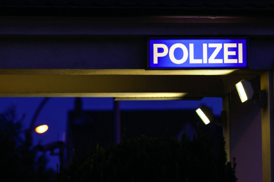 Ein Schild mit der Aufschrift "Polizei" leuchtet am Eingangsbereich einer Polizeistation. (Symbolbild)