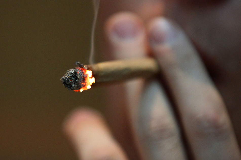 Ein Mann raucht einen Joint. Kann Cannabis-Konsum Ursache für eine paranoide Schizophrenie sein?