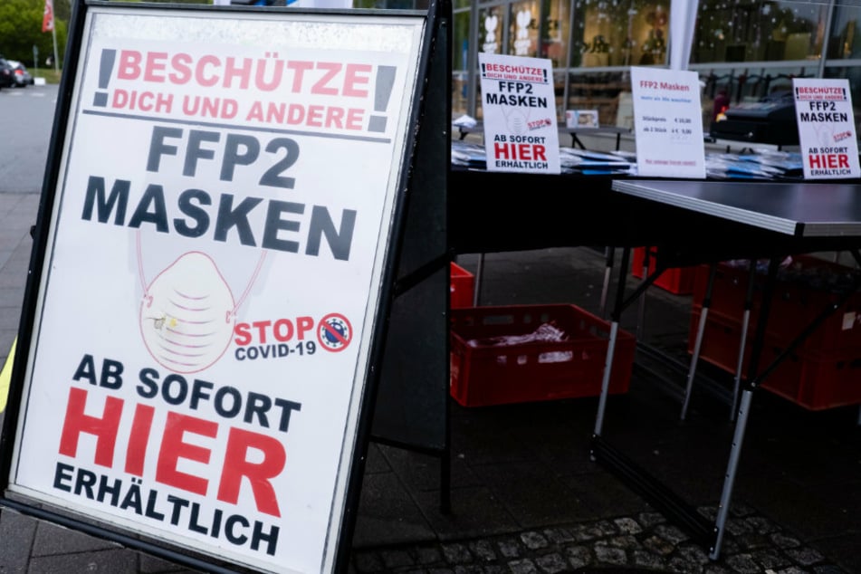 FFP2-Masken werden an einem Stand vor einem Supermarkt angeboten.