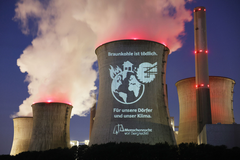 Auf einen Kühlturm des RWE-Kraftwerks in Neurath ließen Umweltaktivisten den Schriftzug "Braunkohle ist tödlich – Für unsere Dörfer und unser Klima" projizieren.