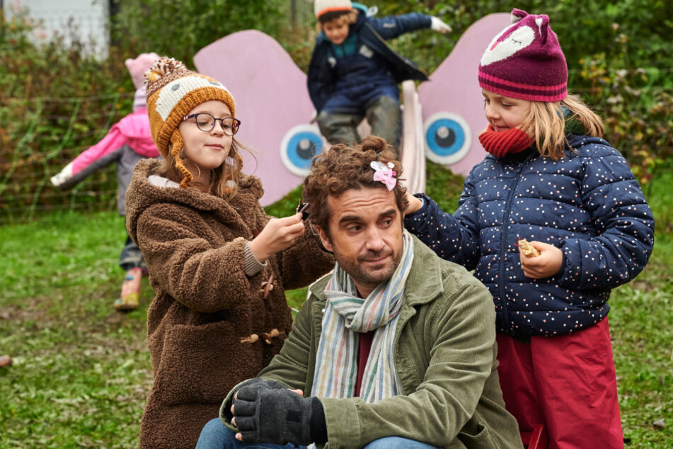 Freddy (Oliver Wnuk) mit Nike (Louisa Renn, li.) und Lisa (Luise Hetmanczyk) in einer Szene des Films "Das Leben ist kein Kindergarten".