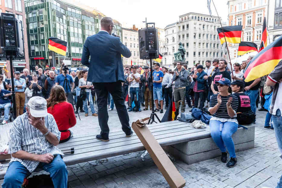 Dennis Augustin, Kreisvorsitzender des AfD Landesverbandes Südwest-Mecklenburg, spricht vor den Teilnehmern der "Merkel muss weg!" Kundgebung auf dem Gänsemarkt.