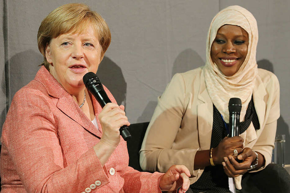 Bundeskanzlerin Angela Merkel das Berliner Start-Up-Unternehmen Kiron und unterhält sich mit Nyima Jadama, Flüchtling aus Gambia, die bei Kiron Politikwissenschaften studiert.