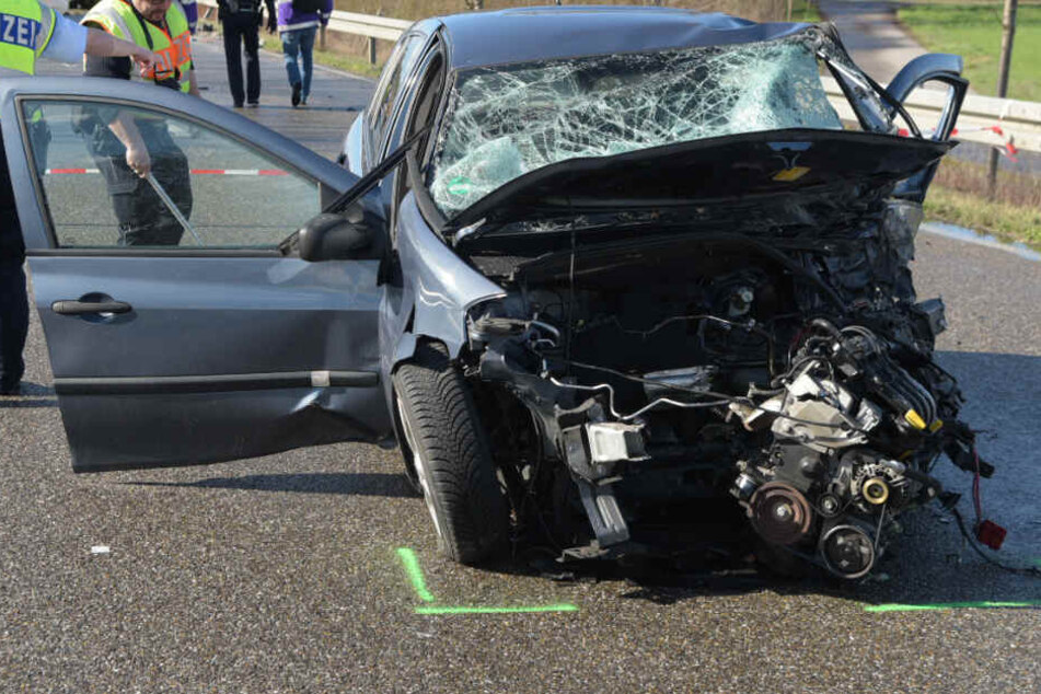 Polizisten vor einem der beteiligten Autos, aus dem der Motorblock herausgerissen wurde.
