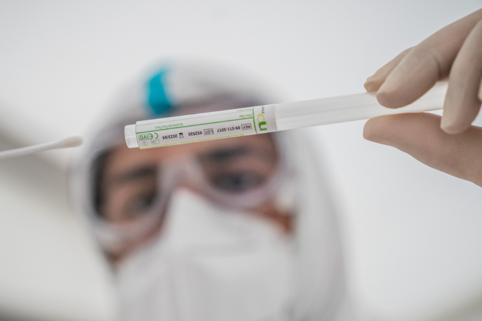Berlin: Ein Mitglied des medizinischen Personals in einem Corona-Testzentrum steckt ein Wattestäbchen nach einem PCR-Abstrich zum Test auf Covid-19 in ein Röhrchen.