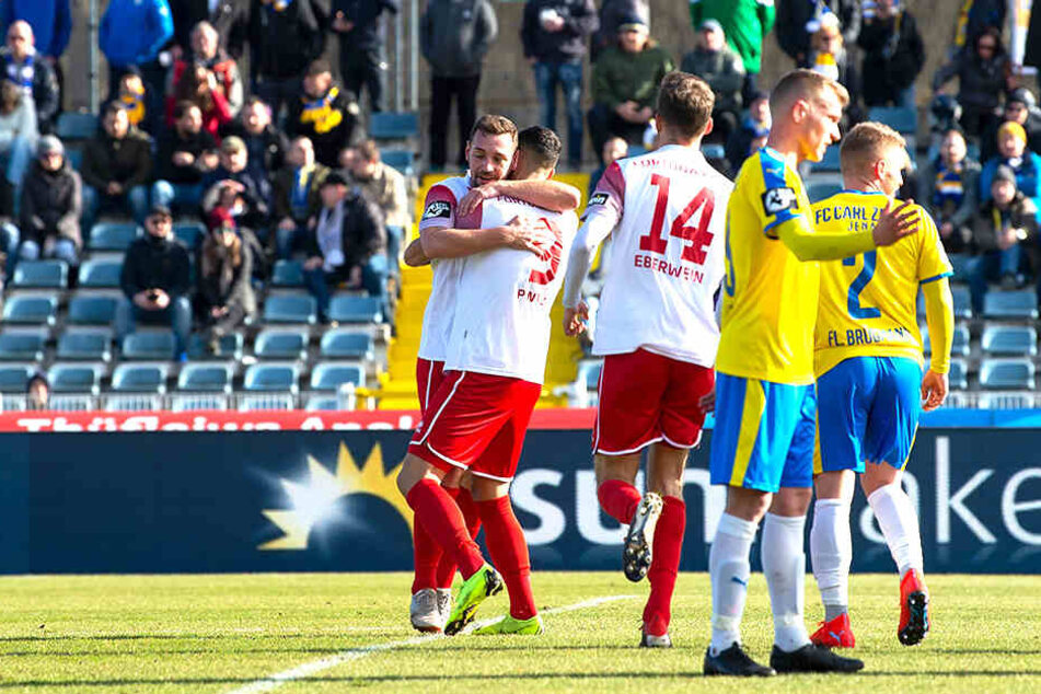 Während Maik Kegel über seinen Führungstreffer jubelt und die Mitspieler gratulieren, machen sich die Mitspieler von Carl Zeiss Jena Mut.
