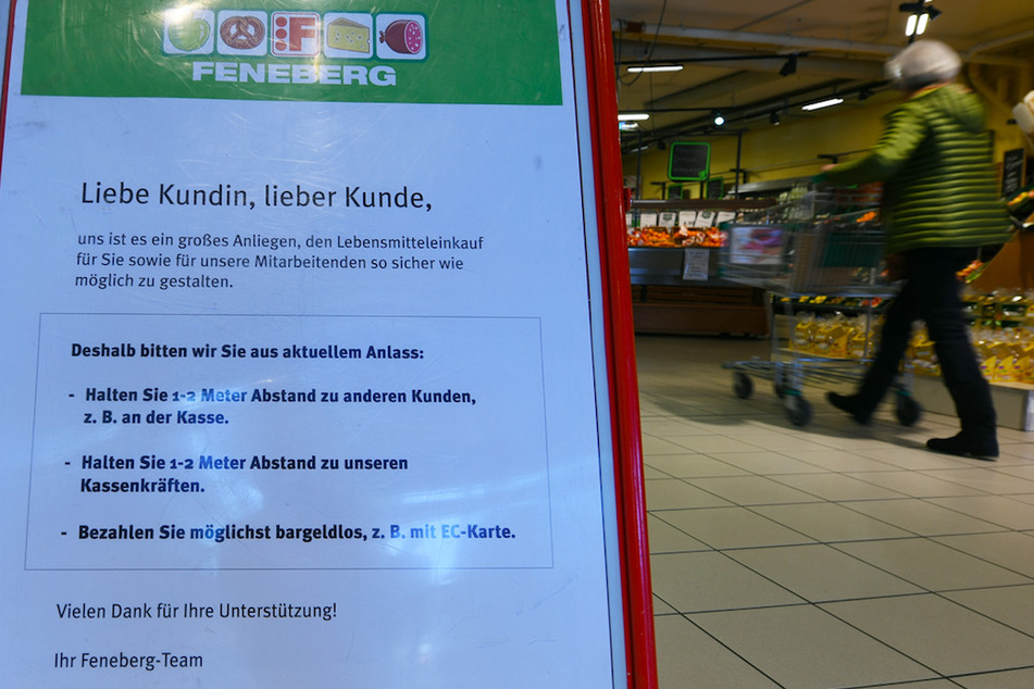 Ein Schild weist in einem Supermarkt auf die richtigen Verhaltensregeln beim Einkaufen hin.