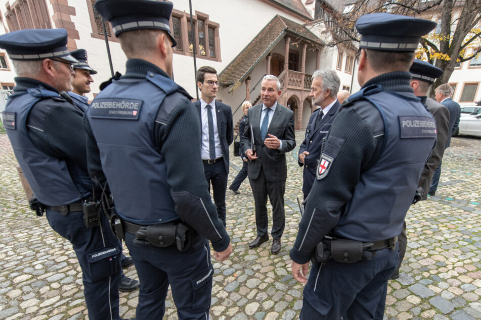 Oberbürgermeister der Stadt Freiburg, Martin Horn (parteilos), Thomas Strobl (CDU), Innenminister von Baden-Württemberg, und Polizeipräsident Bernhard Rotzinger (l-r) sprechen 2018 vor der Unterzeichnung eines Vertrages zur Fortschreibung der Sicherheitspartnerschaft mit Mitarbeitern des Kommunalen Ordnungsdienstes in Freiburg.