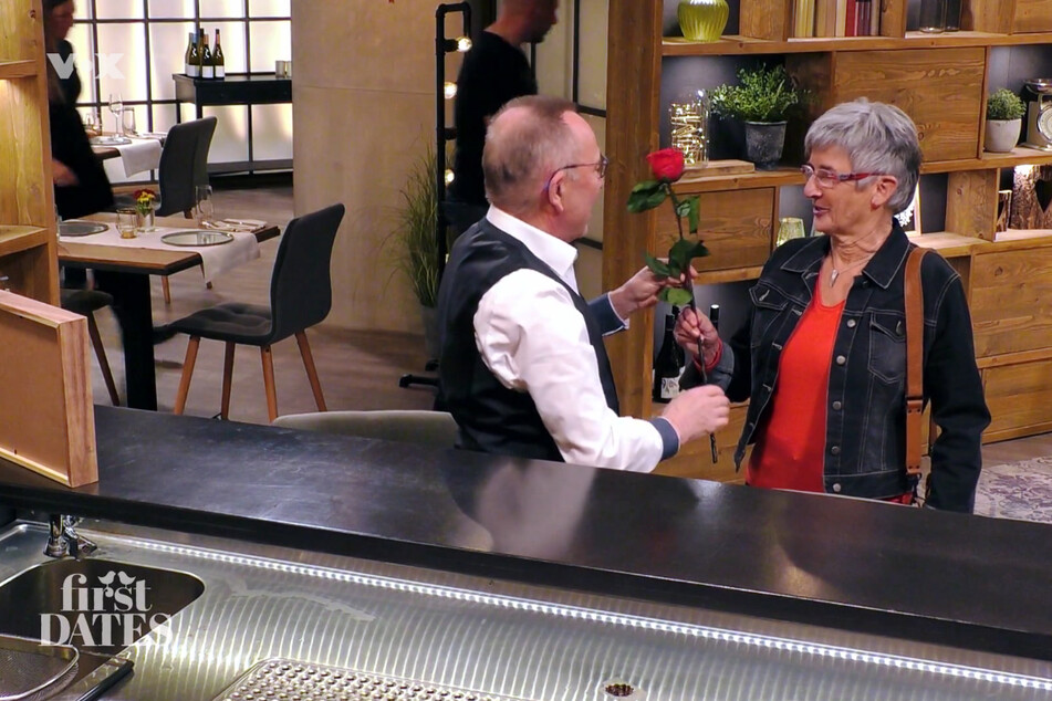 Werner (71) überreicht Monika (67) im "First Dates"-Restaurant eine rote Rose.