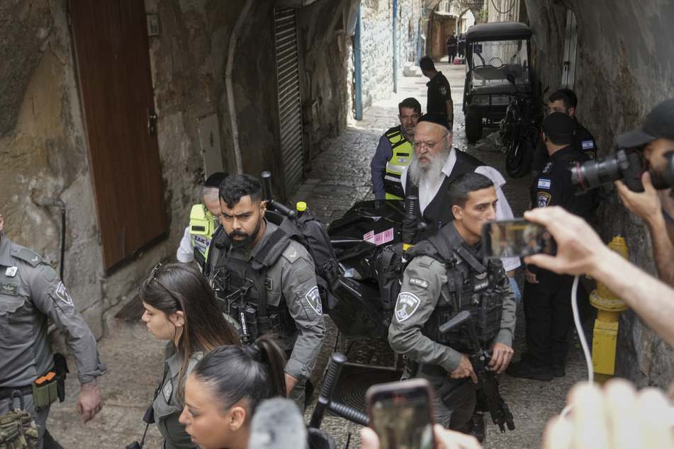 Israelische Sicherheitskräfte und Mitglieder des Rettungs- und Bergungsteams Zaka trugen die Leiche eines Mannes, der von der israelischen Polizei erschossen wurde, nachdem er einen Polizisten bei einem Messerangriff in der Jerusalemer Altstadt verwundet hatte.