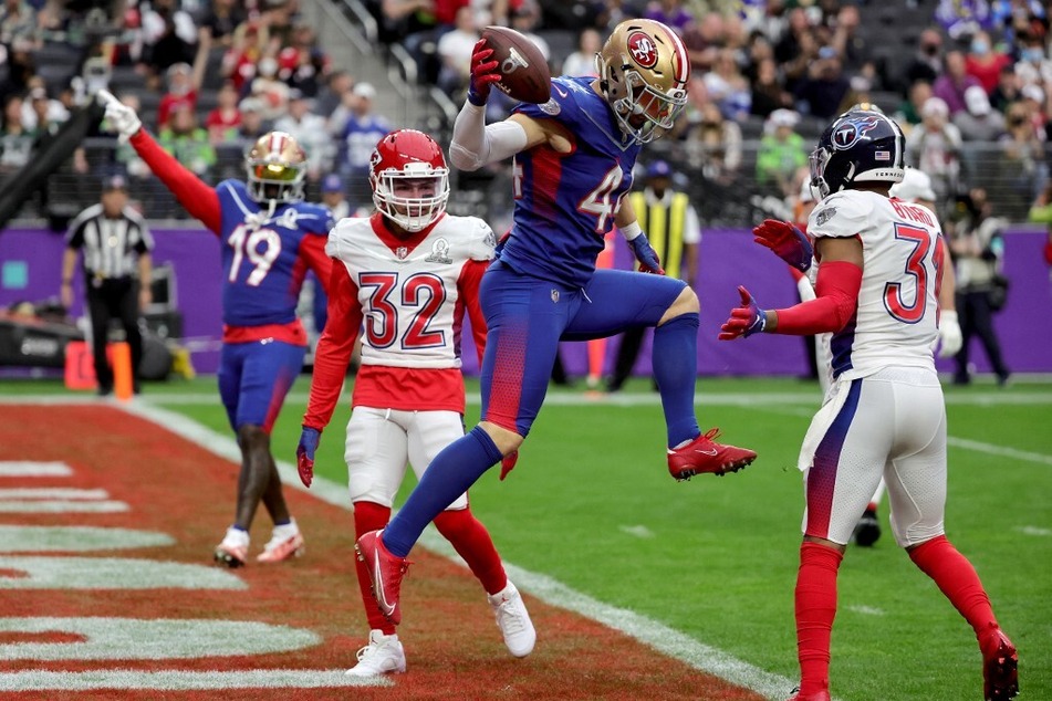 Kyle Juszczyk of the NFC's San Francisco 49ers leaps into the end zone to score a touchdown against the AFC's Tyrann Mathieu of the Kansas City Chiefs and Kevin Byard of the Tennessee Titans during the 2022 NFL Pro Bowl.