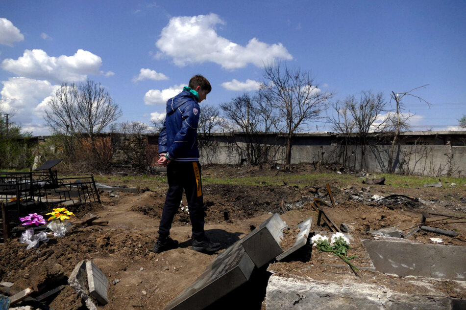 Ein Junge steht am Tag, den die Ukrainer als Tag der Toten begehen, zwischen Gräbern in Odessa, die beschädigt worden sind.
