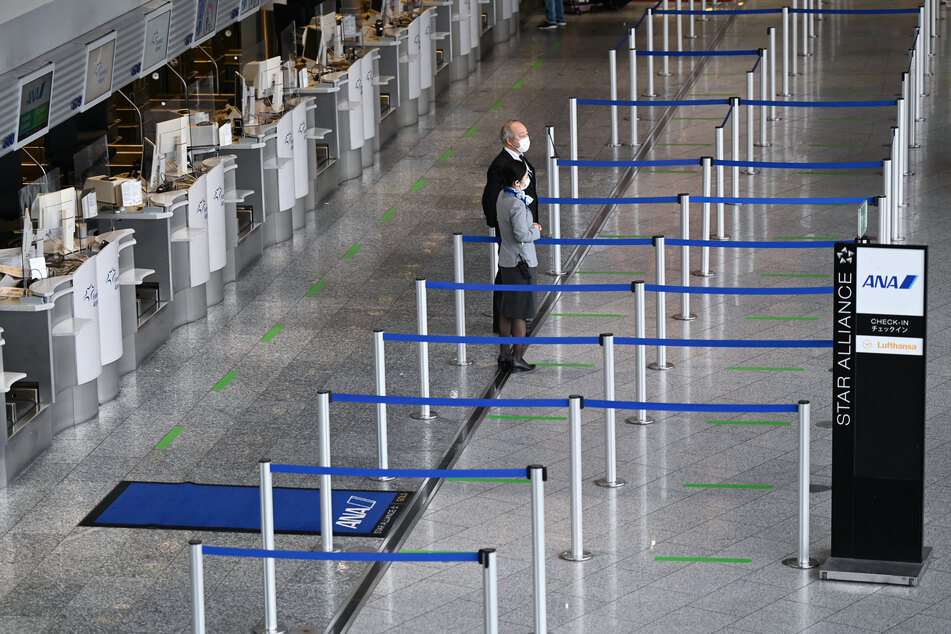 Frankfurt/Main: Mitarbeiter der Fluggesellschaft ANA stehen im Terminal 1 des Frankfurter Flughafens vor den leeren Abflugschaltern. Corona hat die Zahl der Passagiere an den deutschen Flughäfen auf den niedrigsten Stand seit der Wiedervereinigung gedrückt.