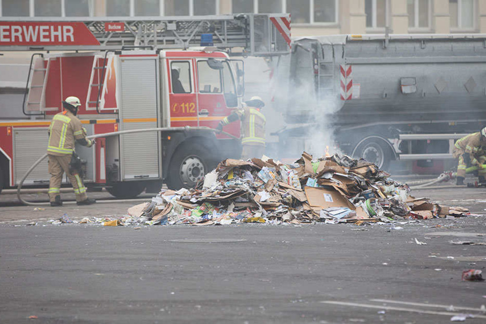 Feuerwehrkräfte löschen gezielt die aufgeschütteten Papierhaufen.