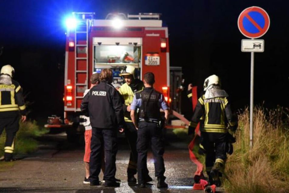 Die Polizeibeamten und die Feuerwehrleute sprechen mit dem Eigentümer.
