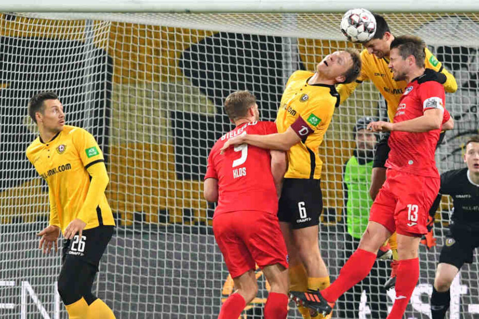 Sieht aus wie Abstiegskampf, ist es auch. Die Dresdner Marco Hartmann und Janniks Nikolaou im Kopfballduell mit Bielefelds Julian Börner (Nummer 13).