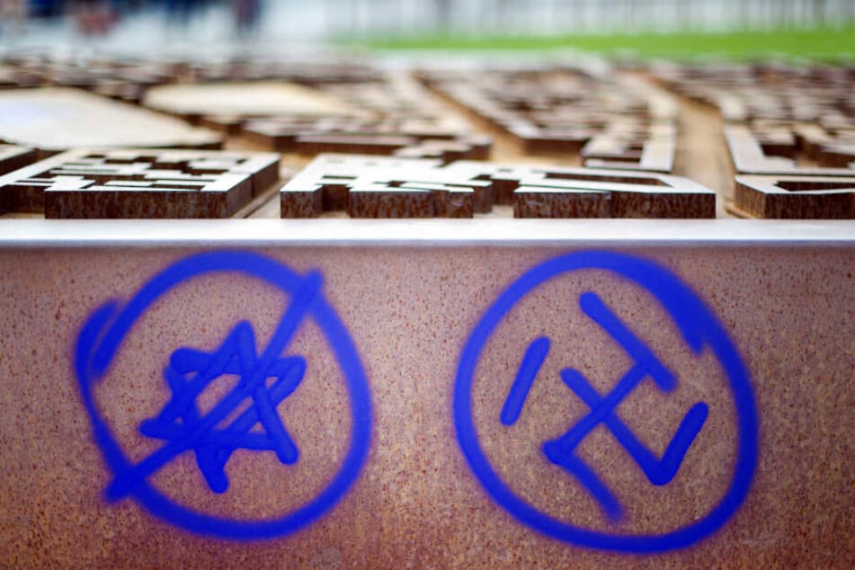 Ein Hakenkreuz und ein durchgestrichener Davidstern an einer Gedenkstätte. (Archiv)