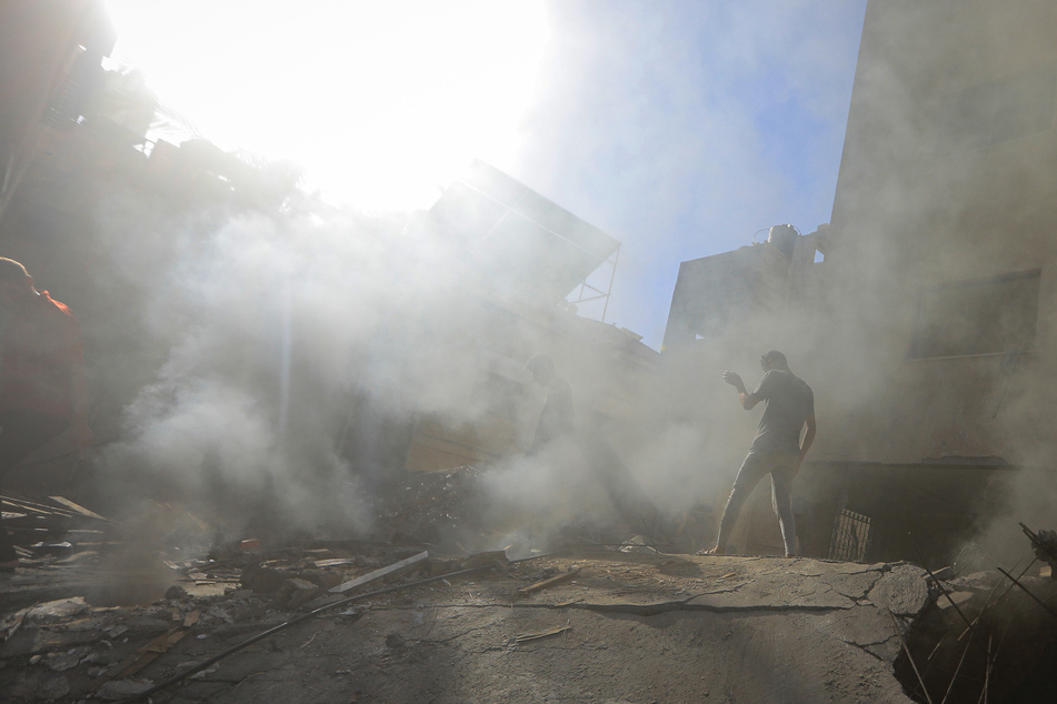 Palästinenser und Mitarbeiter des Zivilschutzes suchen in den Trümmern eines zerstörten Gebäudes nach einem israelischen Luftangriff auf Chan Junis nach Überlebenden.