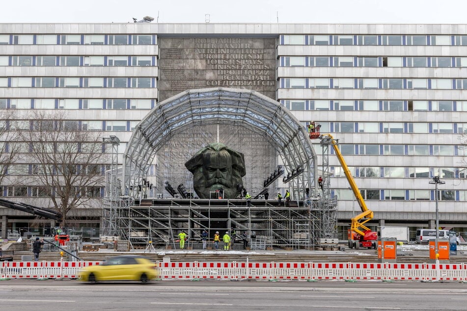 Auf dem Neumarkt sind Techniker mit dem Aufbau einer großen Bühne beschäftigt.