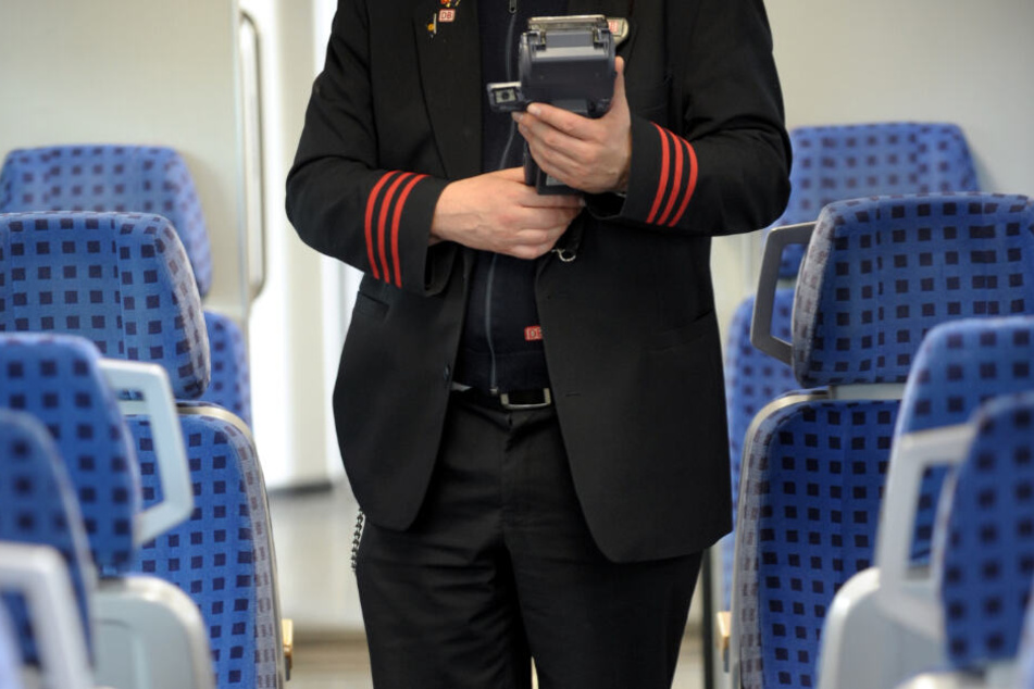 Ein Schaffner steht in einem Zugabteil. Tausende Online-Tickets wurde laut Polizei mit geklauten Kreditkarten-Daten bezahlt. (Symbolbild)