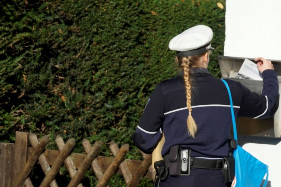 Eine Polizistin informiert Anwohner über den bevorstehenden DNA-Massentest.