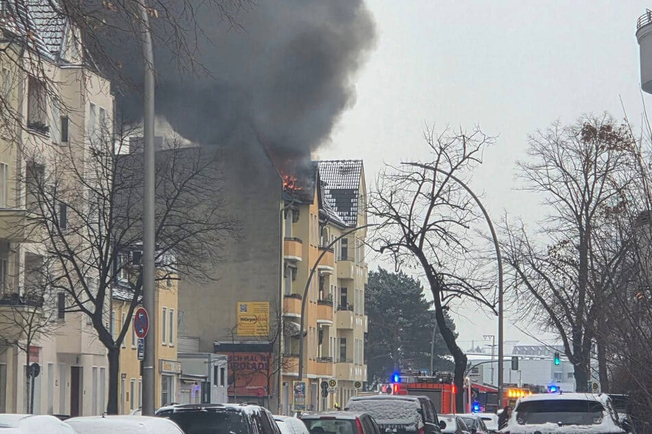 Eine dunkle Rauchwolke stieg über dem Dach des brennenden Hauses auf.