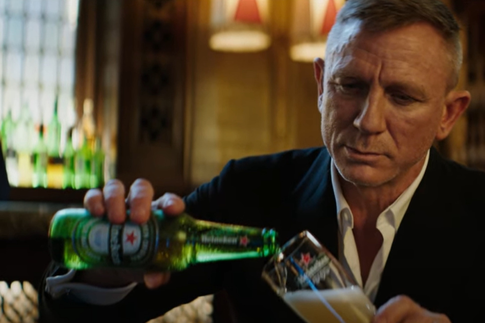 Schauspieler Daniel Craig (53) schüttet sich seelenruhig ein Glas Bier ein. In dem witzigen Filmchen spielt der 007-Mime auf die lange Wartezeit an.