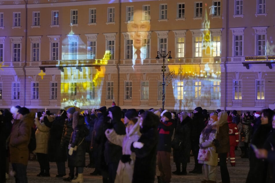 Die Neujahrsbotschaft des russischen Präsidenten Wladimir Putin (72) wird während der Neujahrsfeierlichkeiten auf dem Palastplatz in St. Petersburg auf eine Wand projiziert.