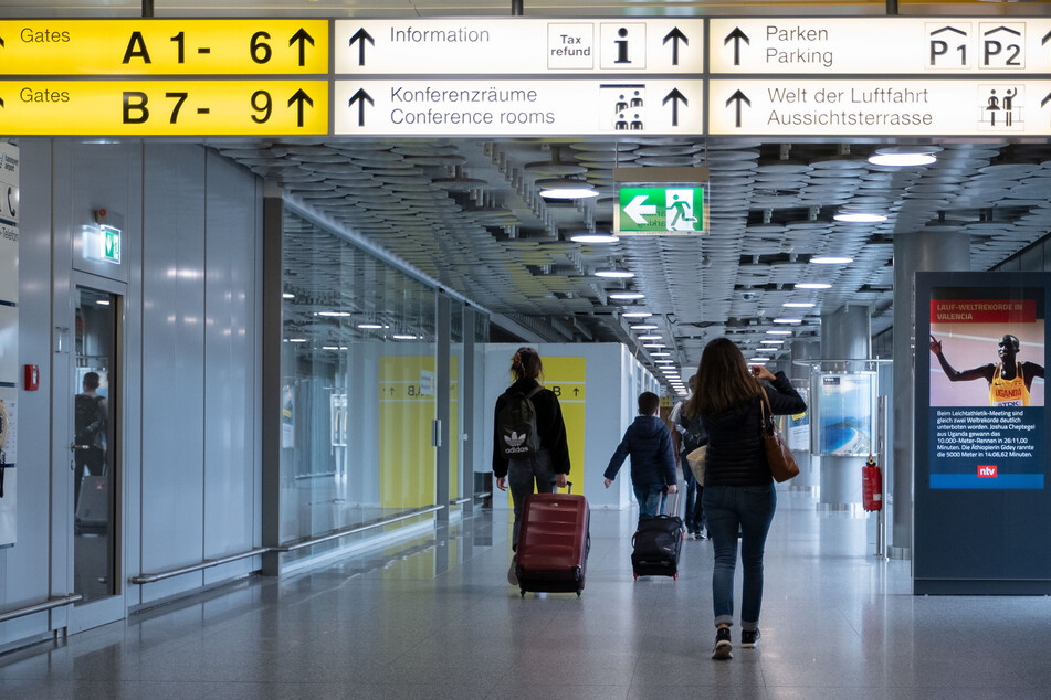 Fluggäste gehen durch das Abflugterminal im Flughafen Hannover.