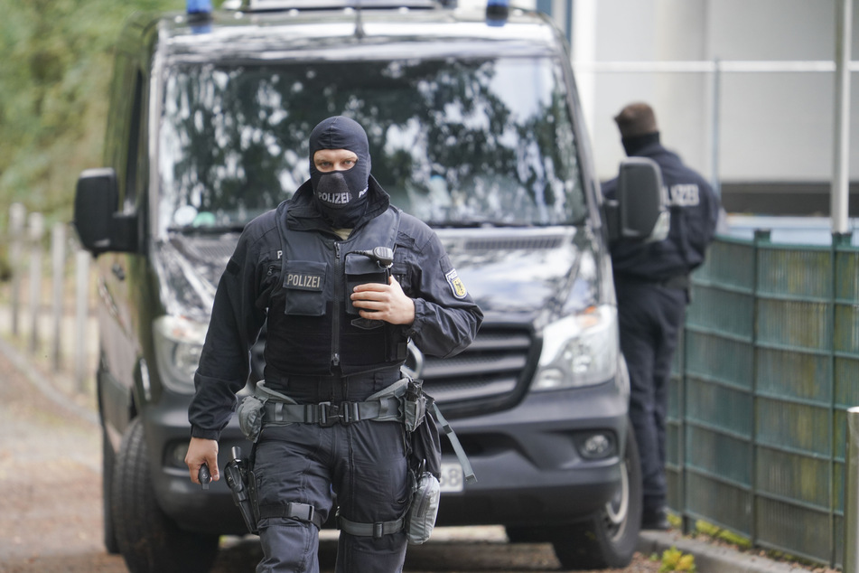 Polizisten in Sturmhauben stehen vor der Rückseite der Zentrale des Deutschen Fußball-Bundes (DFB).