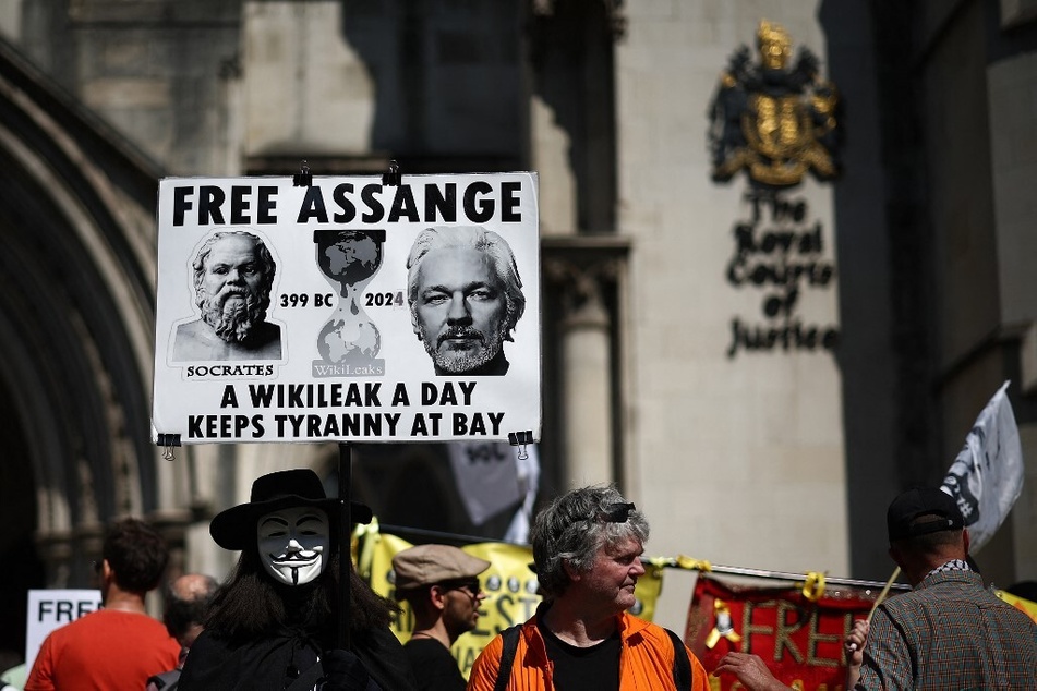 Supporters of WikiLeaks founder Julian Assange hold banners and signs as they protest for his release outside the UK High Court in central London.