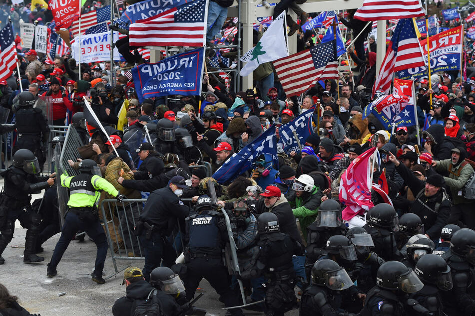 Trump supporters clash with police and security forces as they push barricades to storm the US Capitol in Washington D on January 6, 2021. Demonstrators breached security and entered the Capitol as Congress debated the 2020 presidential election Electoral Vote Certification.