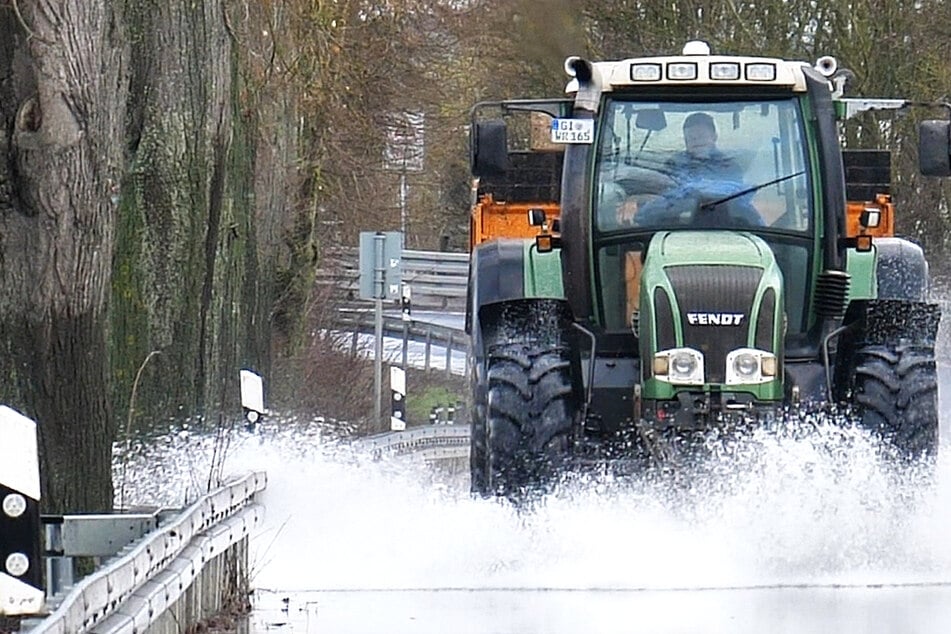 Hochwasser im mittelhessischen Heuchelheim: Ein Traktor fährt über die überschwemmte Lahnparkstraße.