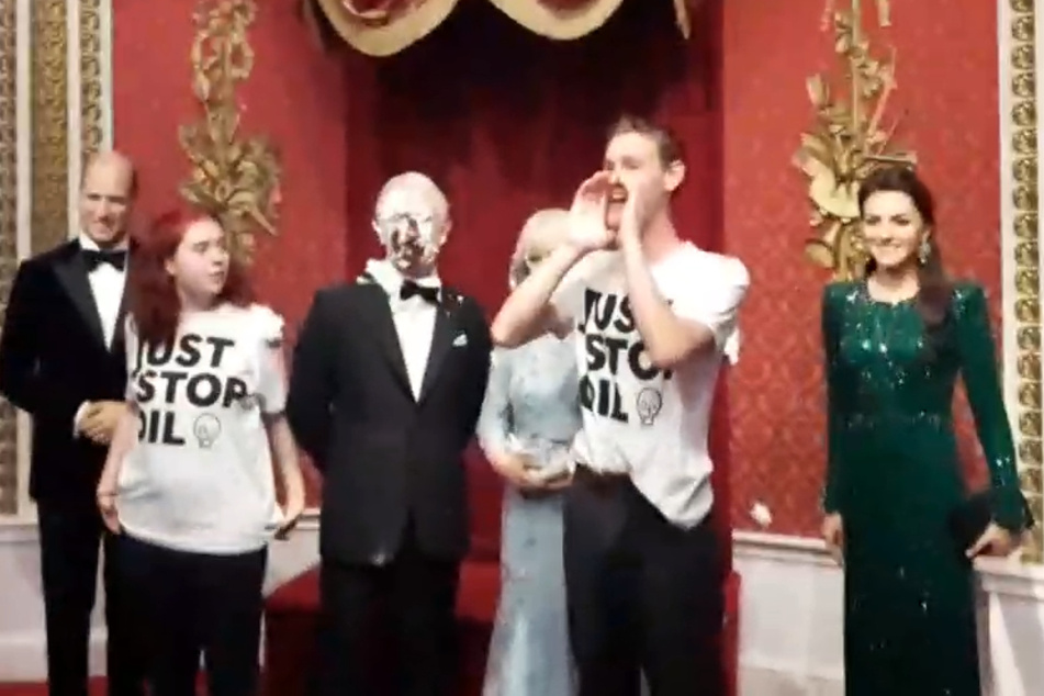Das Videostandbild zeigt die Aktivsten von "Just Stop Oil" inmitten der königlichen Figurengruppe während der Aktion in London.