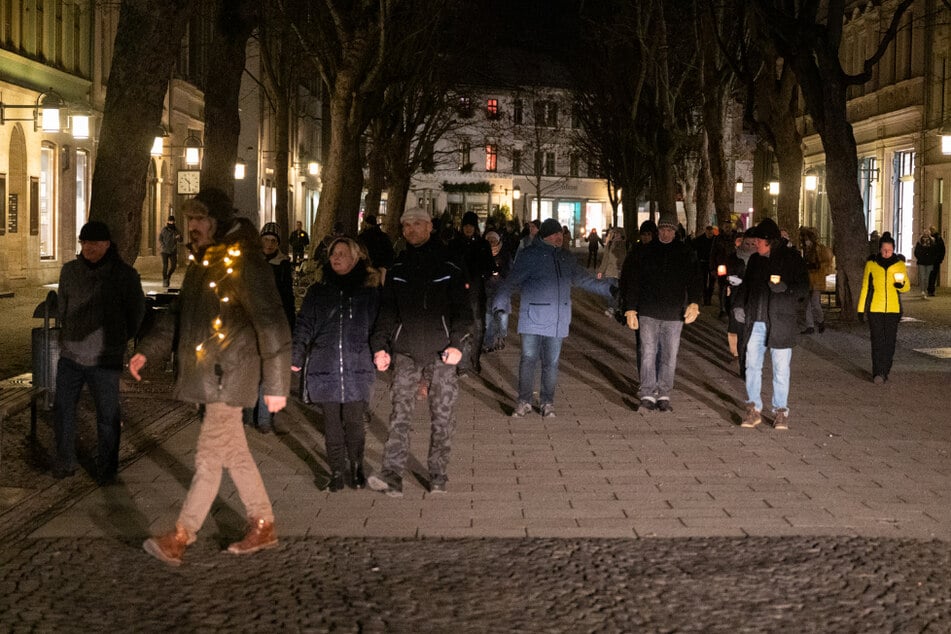 Menschen laufen ohne Mund-Nasen-Bedeckung durch die Innenstadt von Weimar.