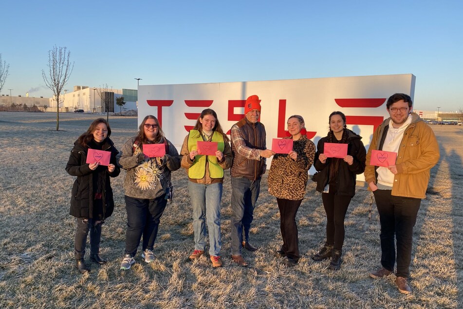 Workers United representatives and Tesla Workers United organizing committee members pose together outside the company's gigafactory in Buffalo, New York.