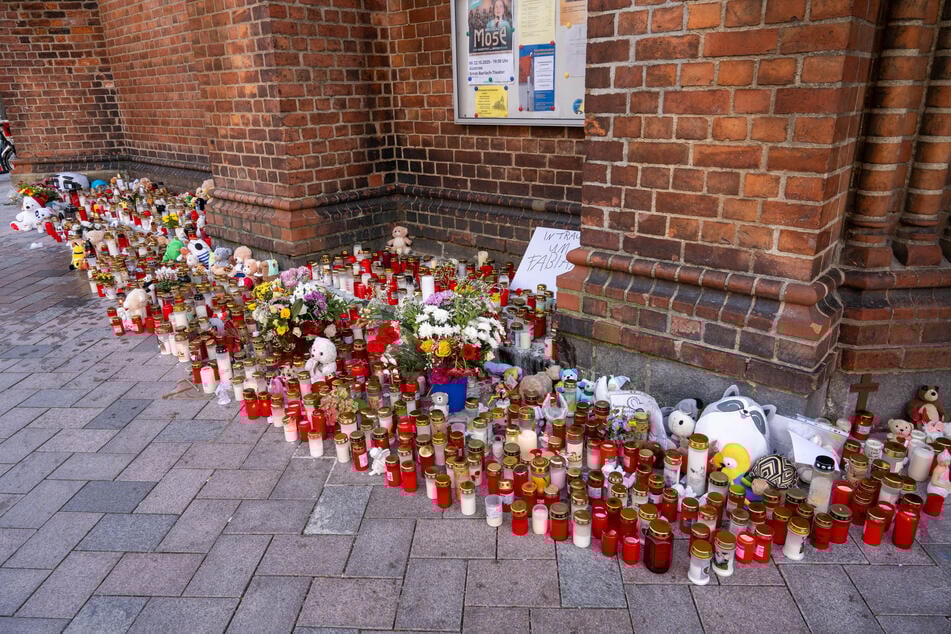 Vor der Marienkirche in Güstrow stehen Grablichter, Blumen und Plüschtiere im Gedenken an den kleinen Fabian.