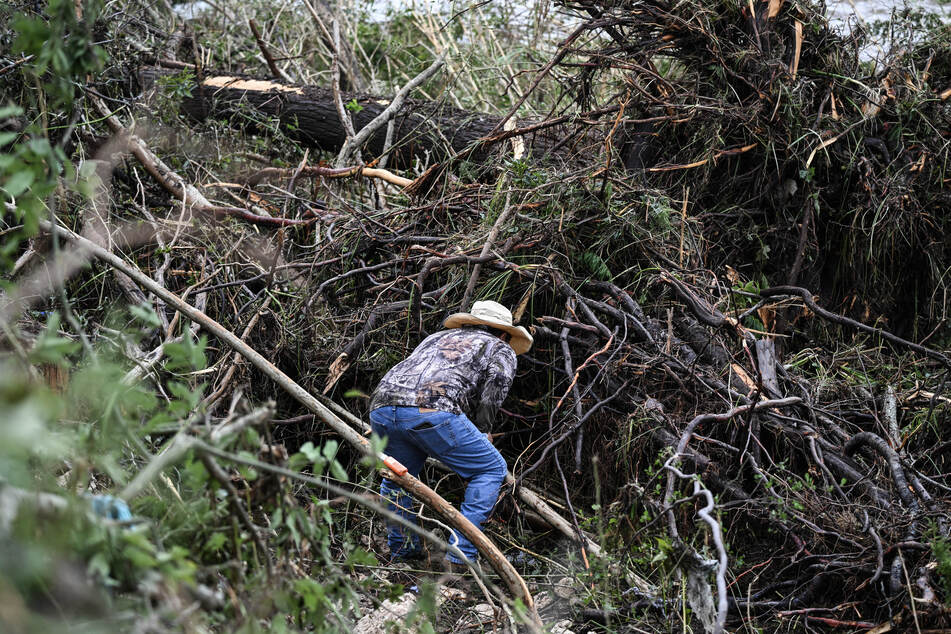 A man helps search for missing people near Camp Mystic, the site of where at least 20 girls went missing after flash flooding in Hunt, Texas, on Saturday.