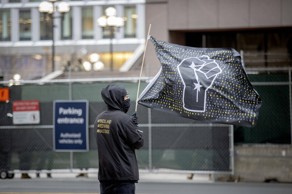 A protester stands outside the Minneapolis courthouse where the trial will take place.