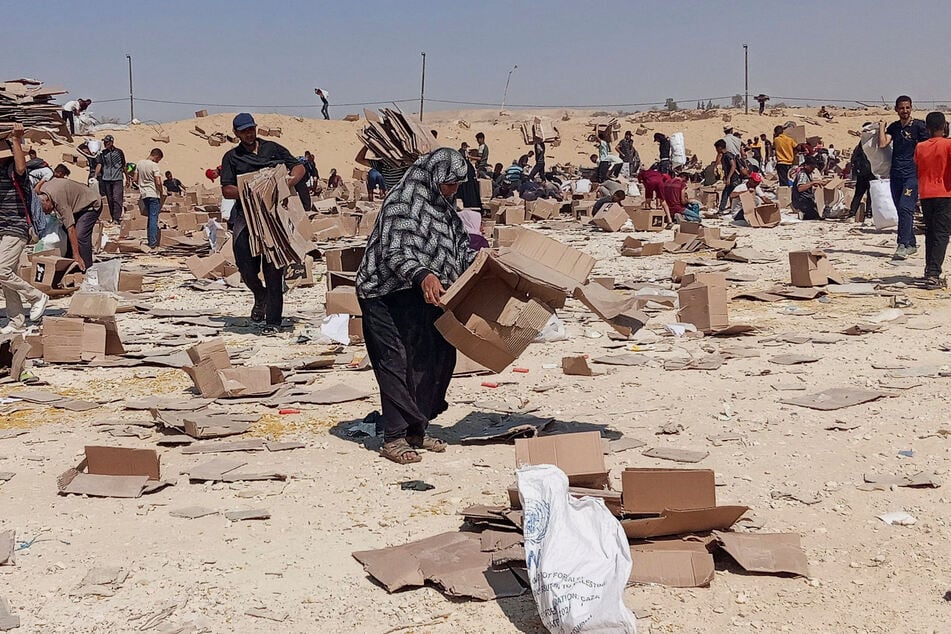 Palestinians gather to collect what remains of relief supplies from the distribution center of the US-backed Gaza Humanitarian Foundation in Rafah on June 5, 2025.