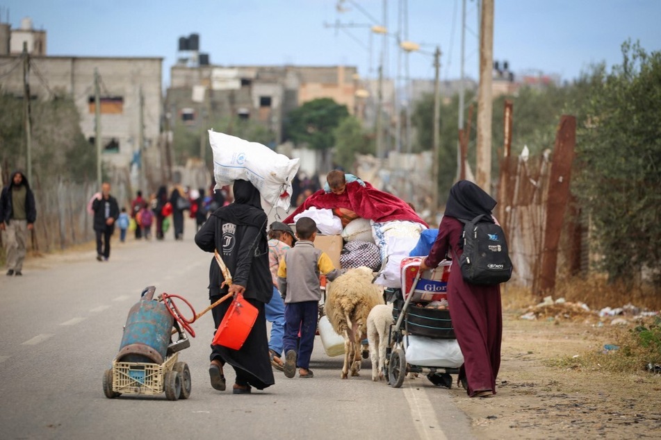 Displaced Palestinians in Rafah in the southern Gaza Strip carry their belongings as they leave following an evacuation order by the Israeli army on May 6, 2024.