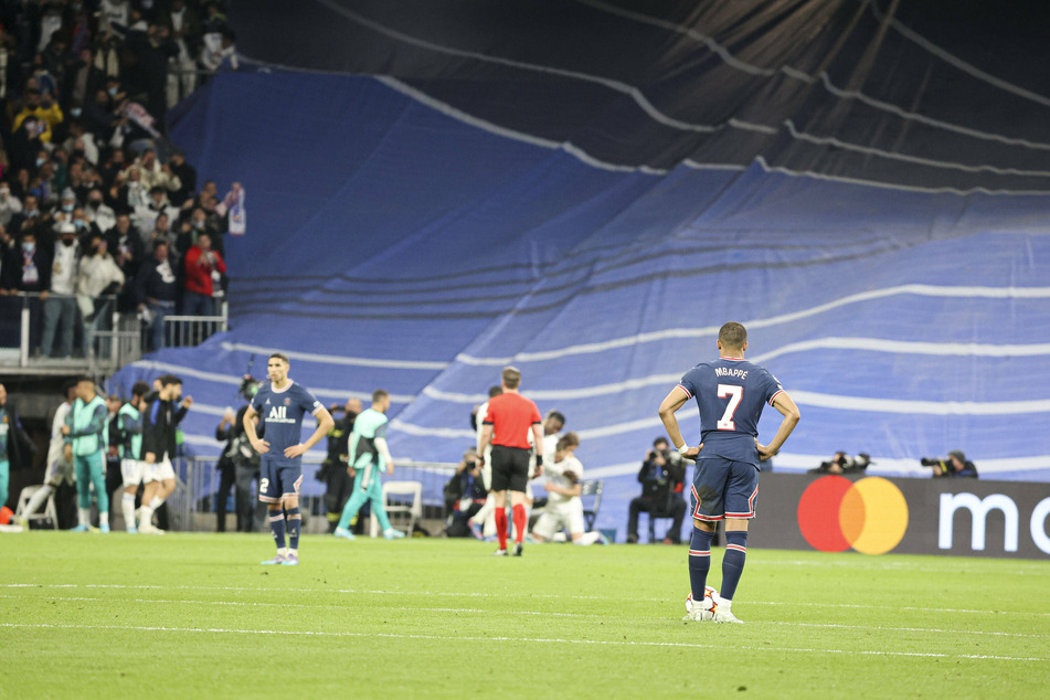 Kylian Mbappé watches on as Real Madrid players celebrate their incredible comeback.