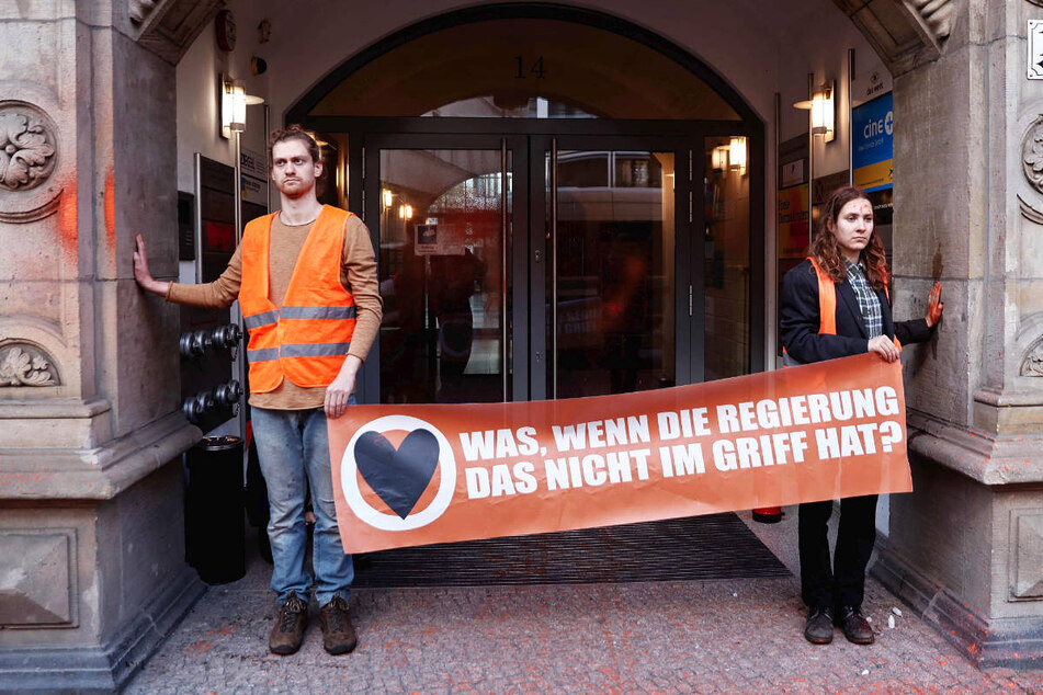 Zwei Aktivisten der "Letzten Generation" haben die FDP-Parteizentrale mit oranger Farbe beschmutzt und sich am Eingang festgeklebt.